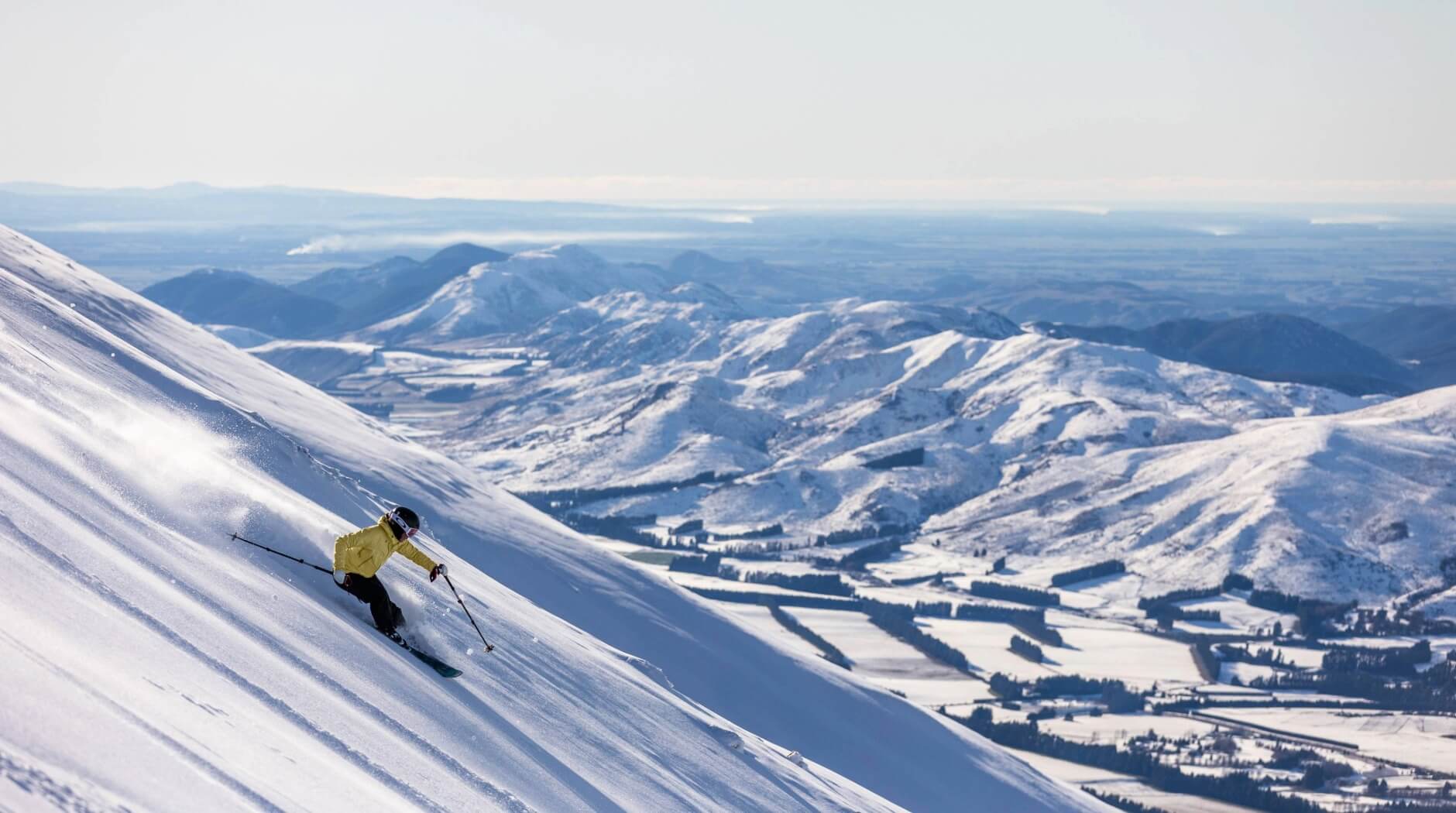 Skier in a yellow jacket on a powder run